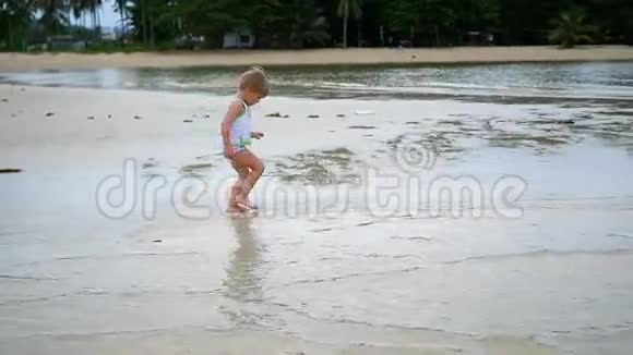 这孩子欢快地沿着海滩奔跑形成了一片浪花视频的预览图