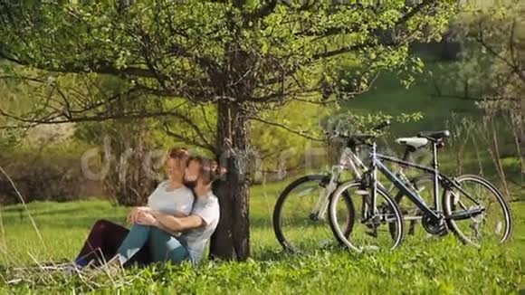 骑自行车的男人和女人坐下来休息视频的预览图