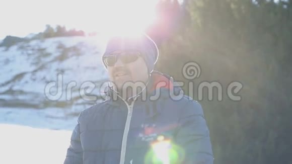 年轻迷人的戴墨镜的人站在阿尔卑斯山的树旁视频的预览图