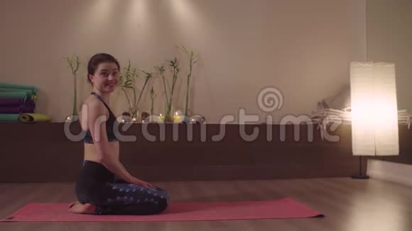 微笑的女人坐在瑜伽工作室里视频的预览图