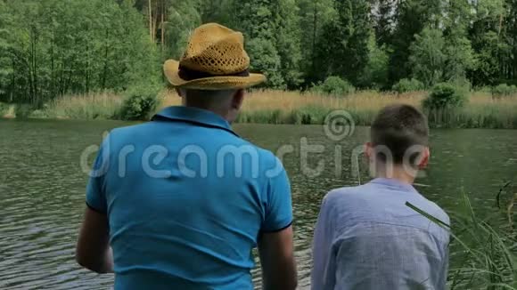 爸爸和儿子在河边钓鱼视频的预览图