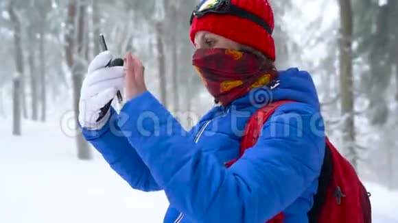 孤独的旅游女孩走在一个冬天白雪覆盖的针叶林山上在一张大自然的照片上视频的预览图