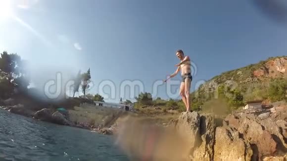 运动中的年轻人从悬崖跳到海洋水上冒险极限运动生活方式业余假期视频的预览图