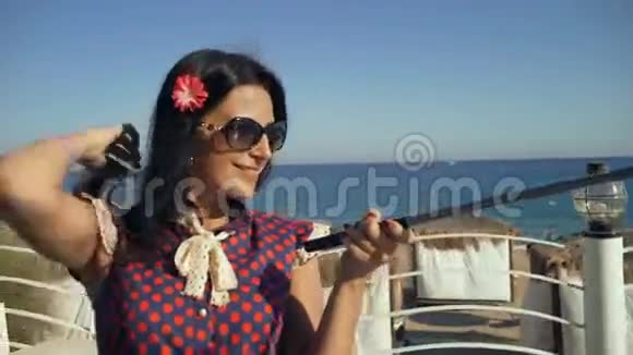 漂亮的年轻微笑的女游客在暑假时在海滩上自拍视频的预览图