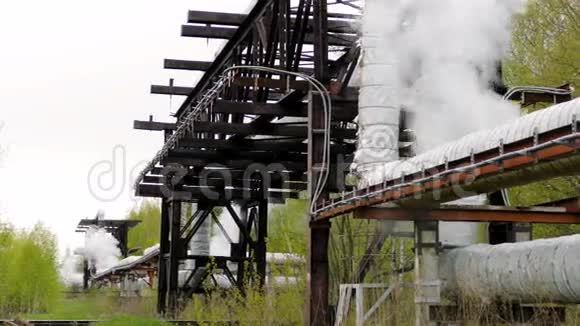管道桥上产生蒸汽喷射的工业管道视频的预览图