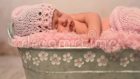 可爱的睡眠新生儿在粉红色的帽子和毯子在婴儿床视频的预览图