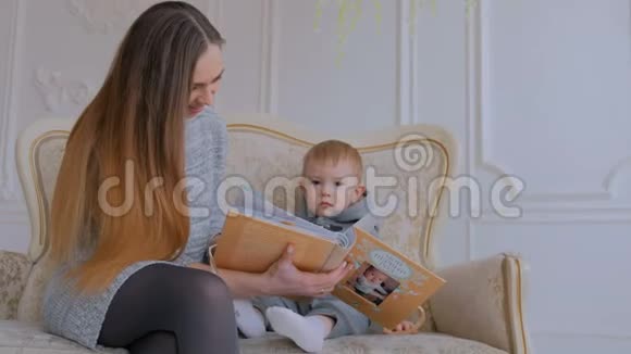 年轻的母亲和她的小儿子正在看照片视频的预览图