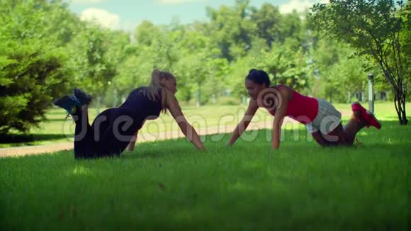 女人推动锻炼健身妇女在公园里推绿草视频的预览图