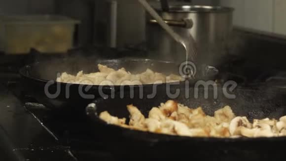 在慢动作的煤气炉上在厨房餐厅的煎锅或煎锅中煮炸薯条鸡片肉视频的预览图
