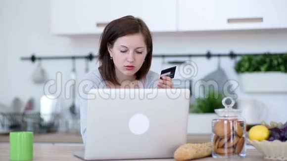 在厨房用笔记本电脑在线购物视频的预览图