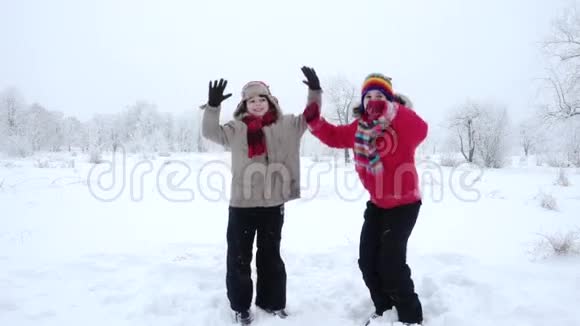 两个孩子在冬天的风景上跳跃慢动作视频的预览图