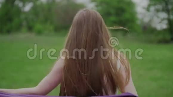 快乐的女人与披风跑过绿色公园视频的预览图