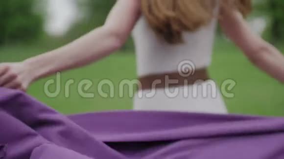 森林中紫色披风的快乐女人视频的预览图