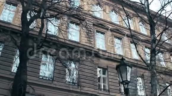 在捷克共和国布拉格的欧洲古典建筑上用无叶的树木拍摄了Stadicam4K低角视频视频的预览图