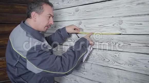 工人用尺子量一堵木墙视频的预览图