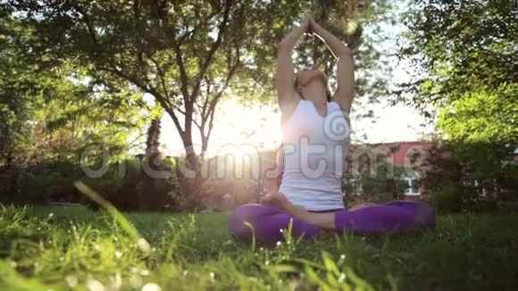 瑜伽练习女人坐在公园的草地上沉思视频的预览图