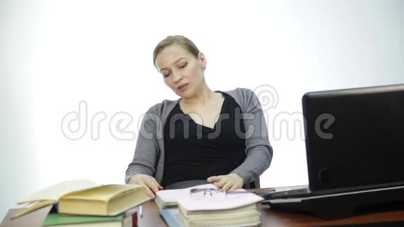 女老师在笔记本电脑前检查教室里的作业视频的预览图