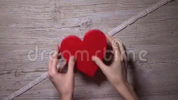女孩用花边丝带系上两颗红心俯视浪漫爱情情人节关系概念4K视频的预览图