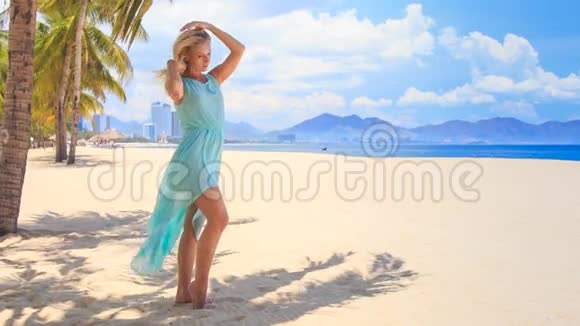金发碧眼的女孩穿着透明的衣服在沙滩上随风飘荡视频的预览图