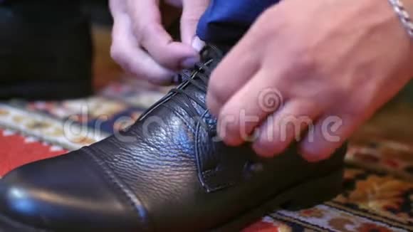 男人把鞋带系在他的黑鞋上视频的预览图
