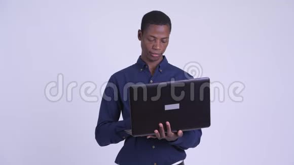 年轻快乐的非洲商人用笔记本电脑思考视频的预览图