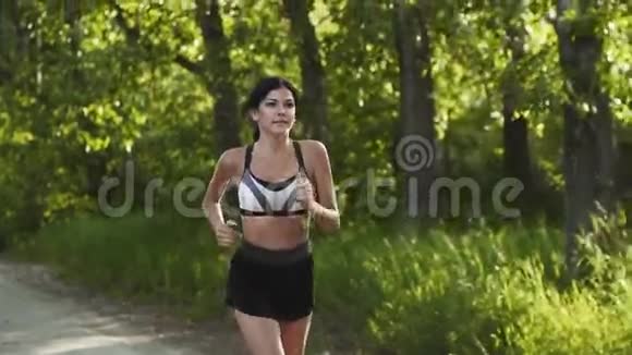 女孩逃跑了日落时年轻的女人沿着马路跑运动员慢跑慢动作视频的预览图