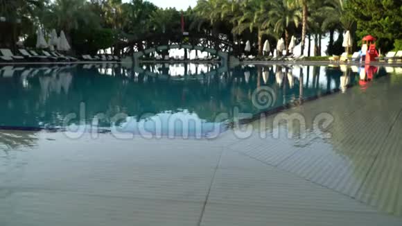 高清视频酒店游泳池周围的日光浴床和雨伞视频的预览图