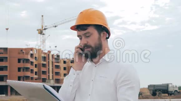 建筑师在工地上用手机交谈视频的预览图