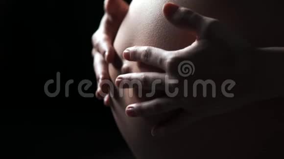 孕妇双手放在她肿胀的肚子上爱情观念视频的预览图