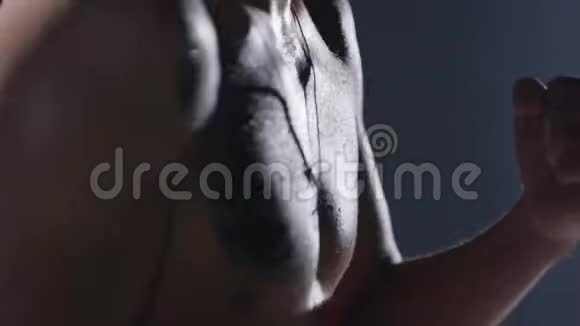 有纹身的男人在一个烟雾弥漫的黑暗房间里打拳击黑烟背景下的攻击性赤膊拳击手视频的预览图