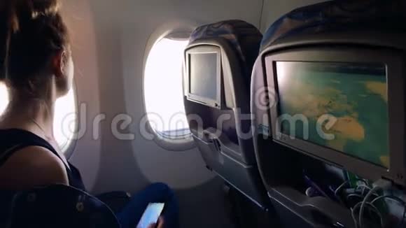 女孩坐在飞机的窗户前从窗户上拍了一张照片视频的预览图