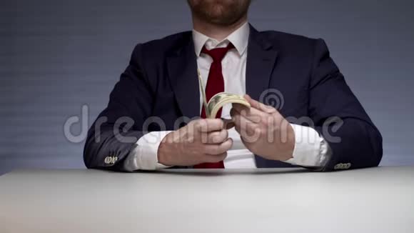 男人手里拿着一捆钱货币利润成功商人视频的预览图