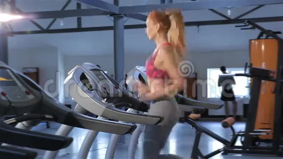 女子在健身中心跑步机上跑步视频的预览图