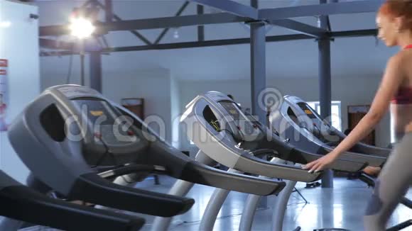 女人打开健身中心的跑步机视频的预览图