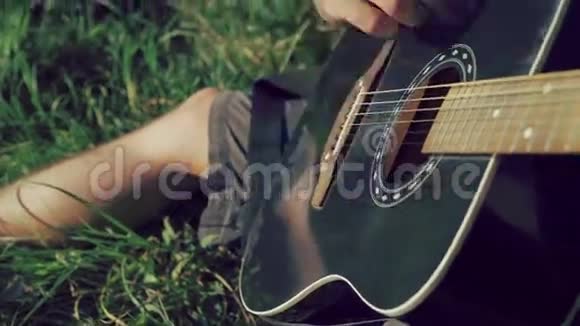 近距离的人手在自然上弹吉他4K视频的预览图