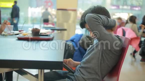 青少年在咖啡馆玩智能手机游戏视频的预览图