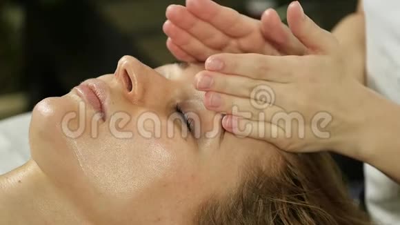 美容师在水疗沙龙为美女做面部按摩慢动作视频的预览图