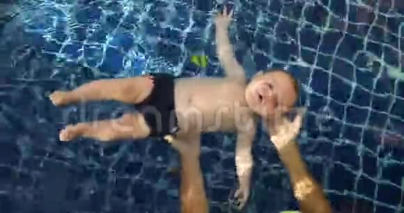 小男孩和父母在游泳池里游泳视频的预览图