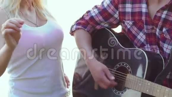 女孩拿着孟加拉灯男孩在湖边弹吉他慢慢地视频的预览图