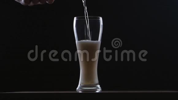 啤酒在黑色背景下倒入玻璃中慢动作视频的预览图