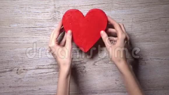 女孩把四颗红心放在一张木桌上俯视花关怀爱情人节的概念4K视频视频的预览图
