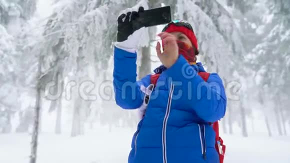 孤独的旅游女孩走在一个冬天白雪覆盖的针叶林山上在一张大自然的照片上视频的预览图