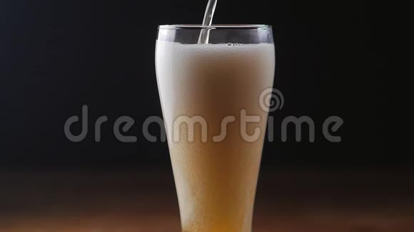 啤酒在黑色背景下倒入玻璃中慢动作视频的预览图
