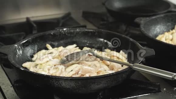 鸡片肉是用煎锅或煎锅煎熟的或用煤气炉在餐厅厨房里慢慢煮视频的预览图