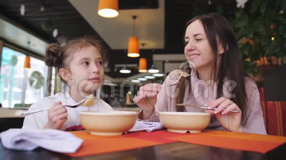 母亲和小女儿一起在咖啡馆吃饭视频的预览图