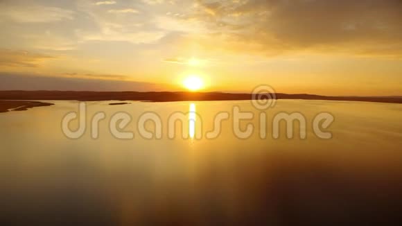 傍晚日落时分金色的阳光反射在水面的河水中视频的预览图