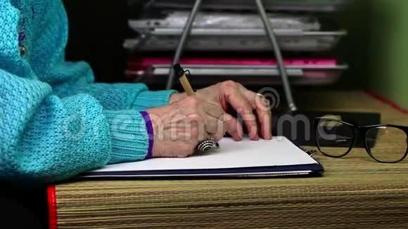 老妇人在桌子旁的纸上写字视频的预览图