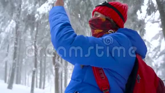 孤独的旅游女孩走在一个冬天白雪覆盖的针叶林山上在一张大自然的照片上视频的预览图