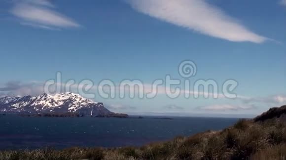南极洲的蓝天和海洋背景上的雪山视频的预览图