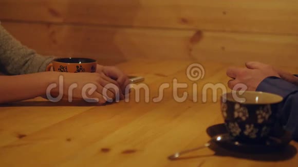 可爱的夫妇坐在咖啡馆里男人轻轻地摸着手女朋友近距离展示年轻男女的双手视频的预览图